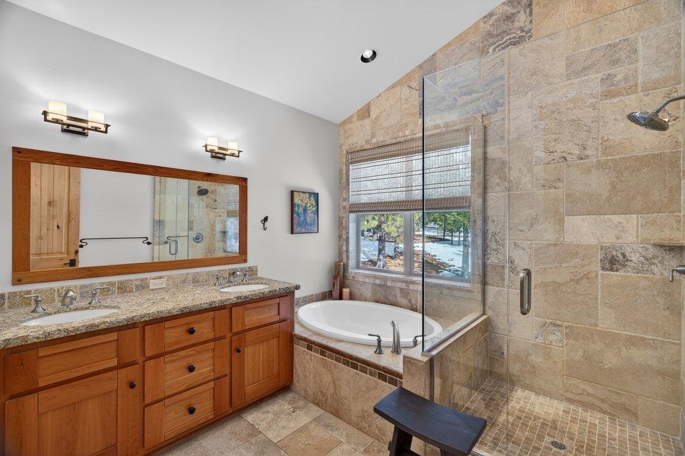 15043 Wolfgang Road Truckee, CA 96161 - Photo 24 of 28 a bathroom with a granite countertop sink a mirror and a bathtub