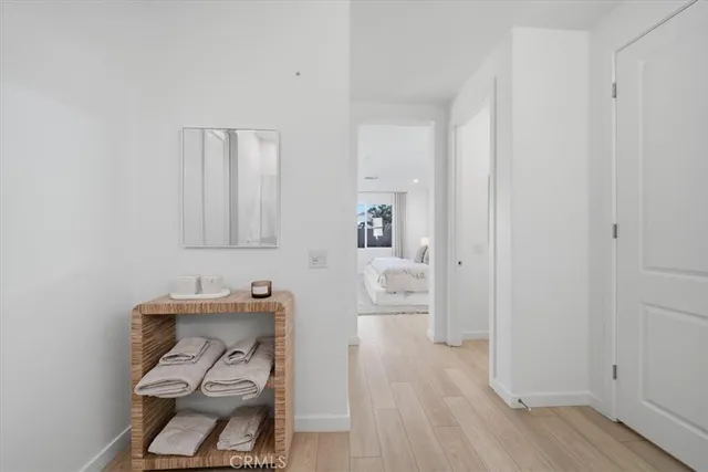 a hallway with a view of bedroom with wooden floor