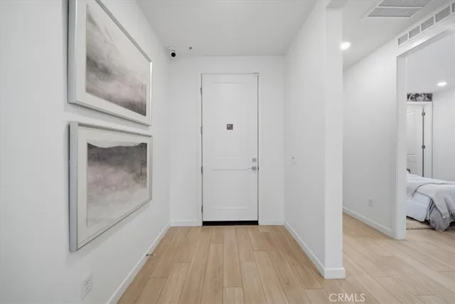 a view of a hallway with wooden floor and closet