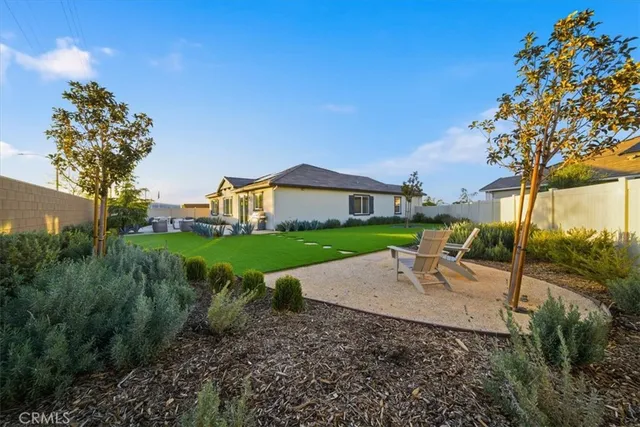a view of a house with garden and a tree