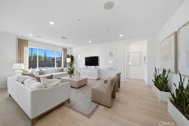 a living room with furniture floor to ceiling window and potted plant