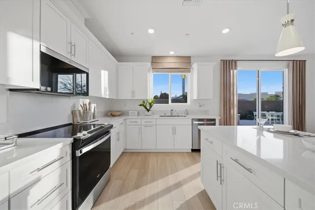 a kitchen with granite countertop a sink stainless steel appliances and cabinets