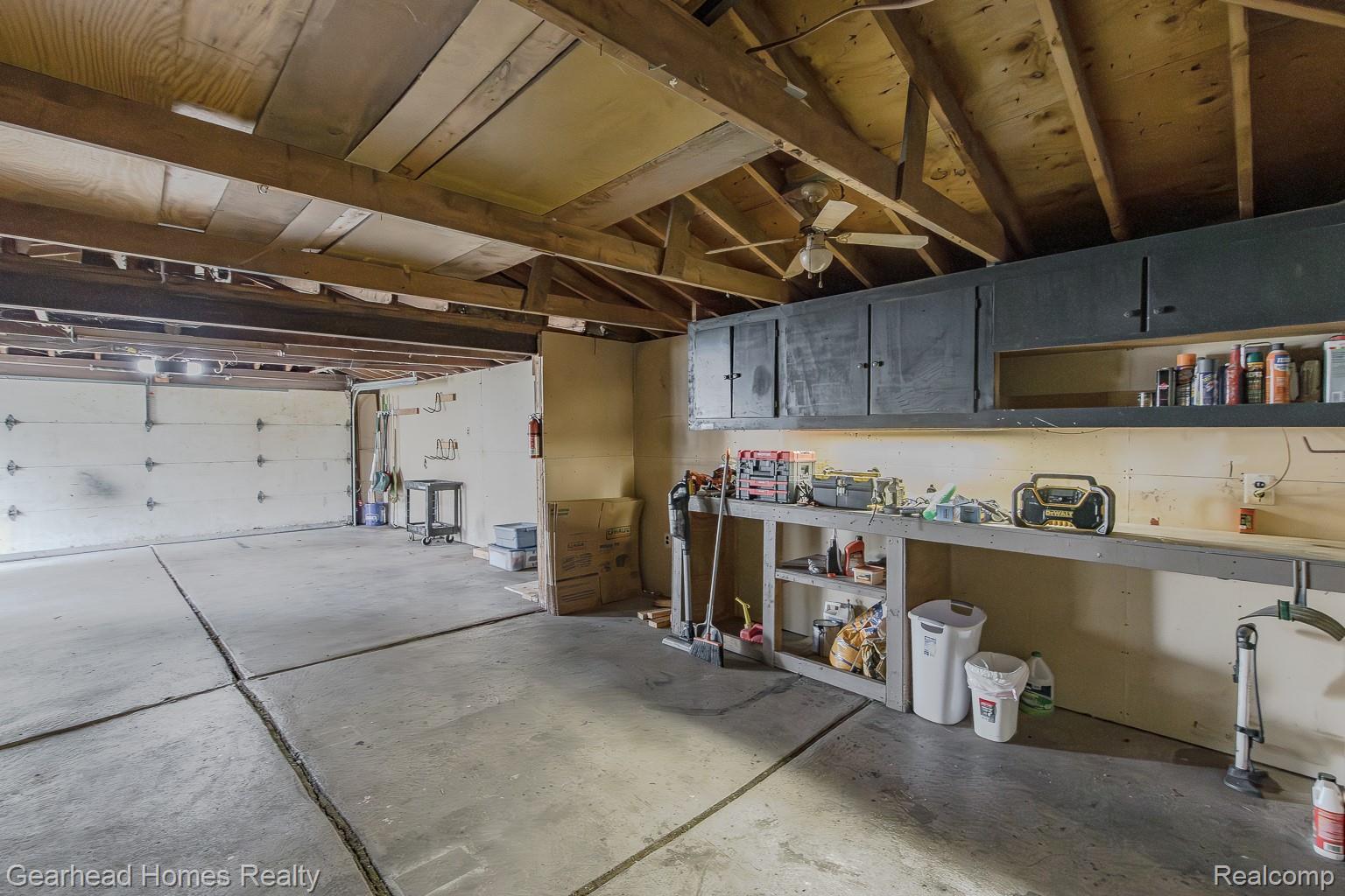 3356 Harding Street Dearborn, MI 48124 - Photo 41 of 48 Spacious garage with concrete flooring, exposed wood beam ceiling, built-in shelving, and overhead cabinetry