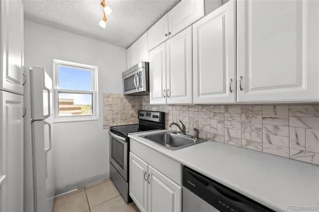 a kitchen with stainless steel appliances white cabinets and a sink