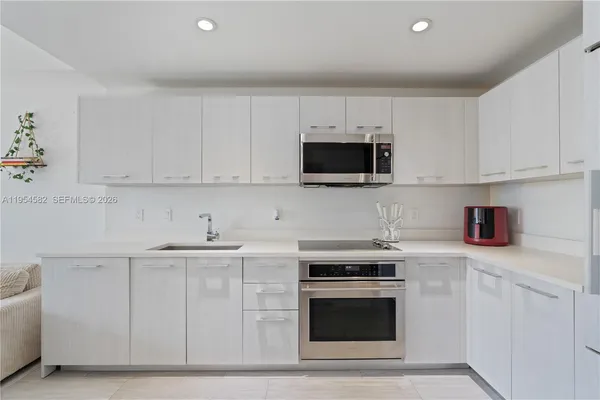 a kitchen with cabinets stainless steel appliances and a counter space