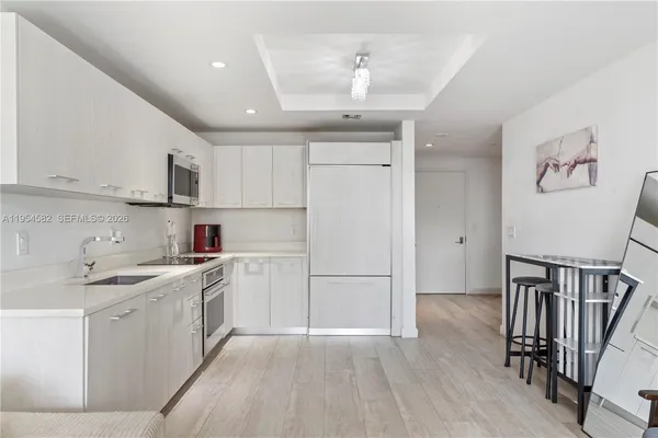 a kitchen with a sink a refrigerator and cabinets