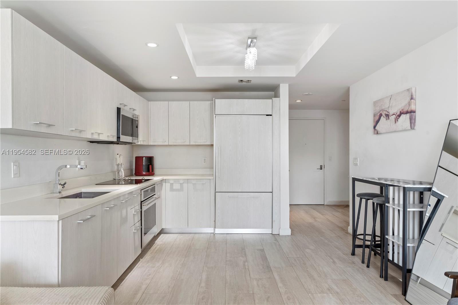 55 Southwest 9th Street, Unit 3005 Miami, FL 33130 - Photo 13 of 23 a kitchen with a sink a refrigerator and cabinets
