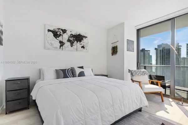 a bedroom with a bed and a painting on the wall