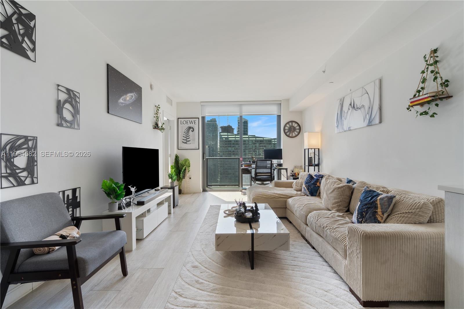 55 Southwest 9th Street, Unit 3005 Miami, FL 33130 - Photo 2 of 23 a living room with furniture and a flat screen tv