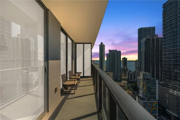 a view of a hallway with a white door and wooden floor