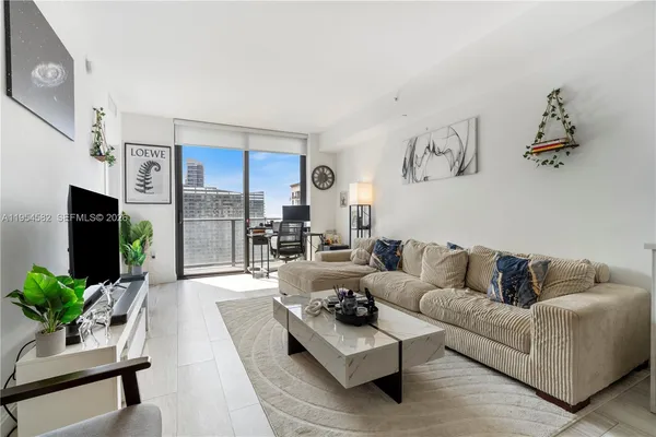 a living room with furniture potted plant and a flat screen tv