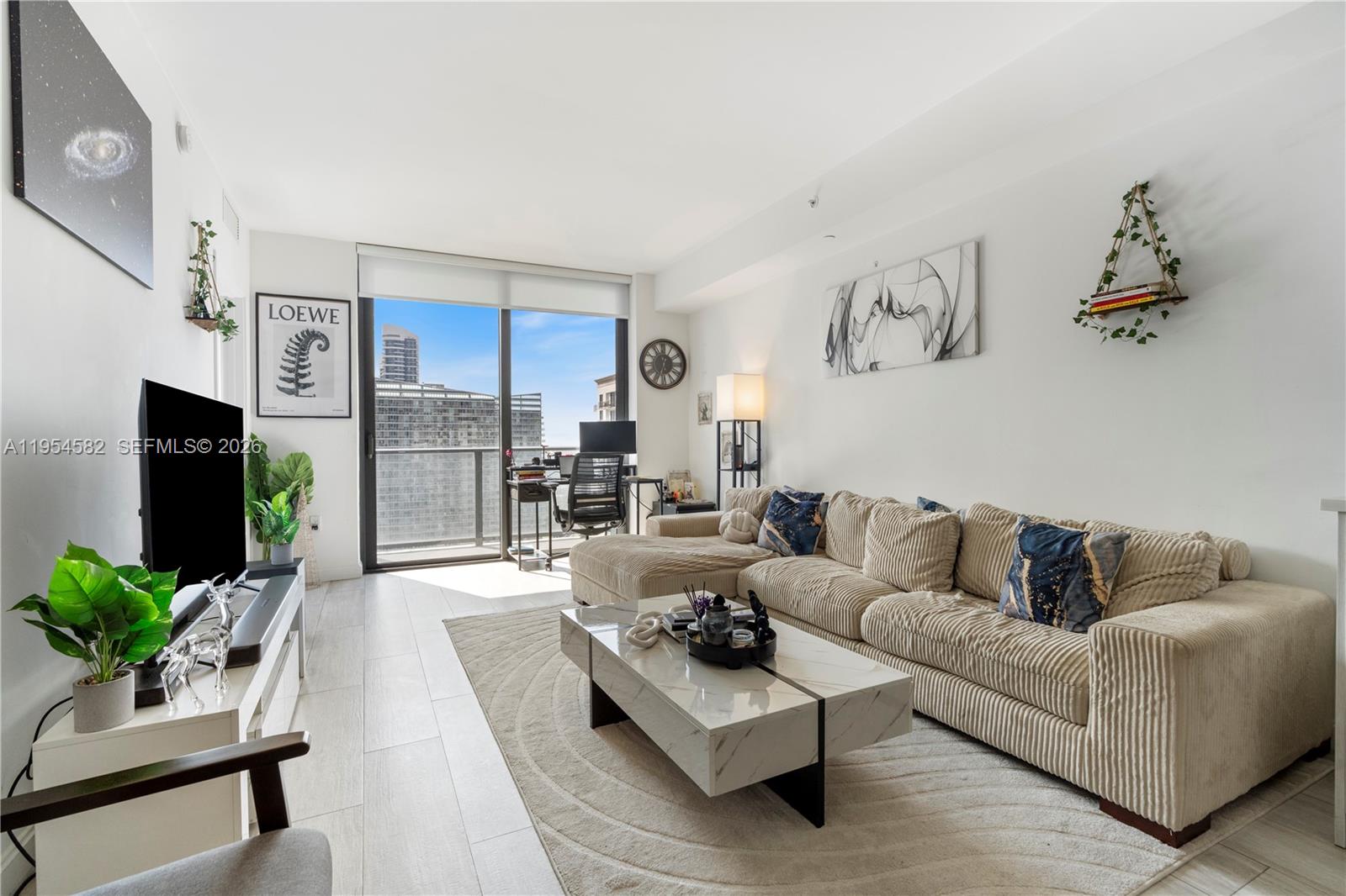 55 Southwest 9th Street, Unit 3005 Miami, FL 33130 - Photo 3 of 23 a living room with furniture potted plant and a flat screen tv
