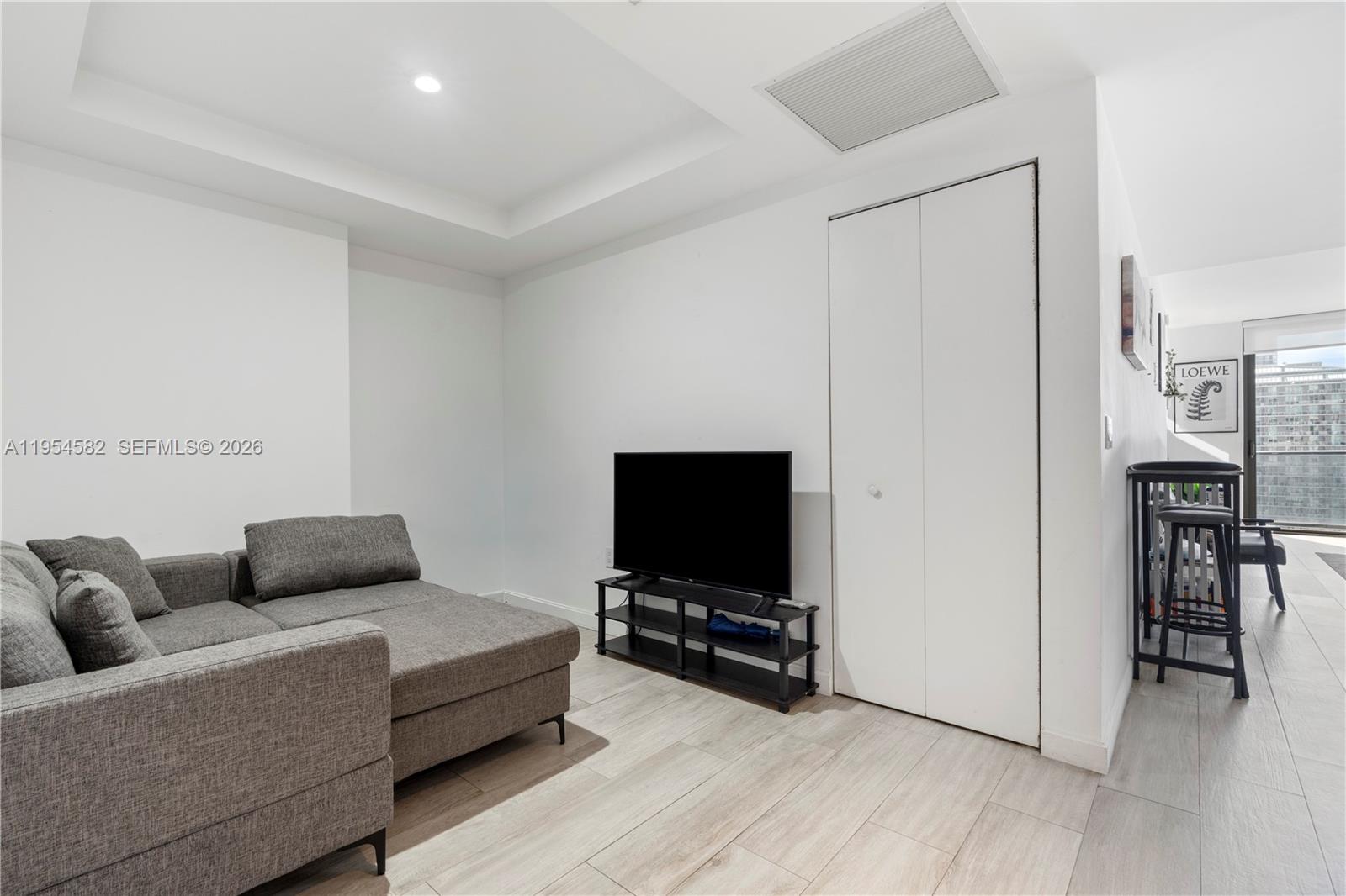 55 Southwest 9th Street, Unit 3005 Miami, FL 33130 - Photo 8 of 23 a living room with furniture and a flat screen tv