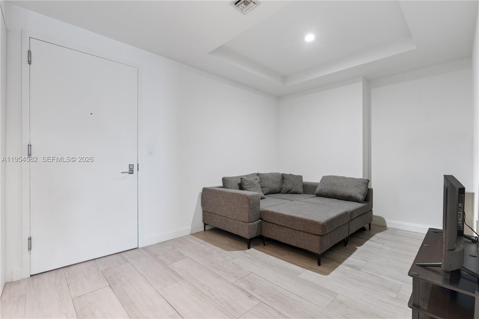 55 Southwest 9th Street, Unit 3005 Miami, FL 33130 - Photo 9 of 23 a living room with furniture and a flat screen tv