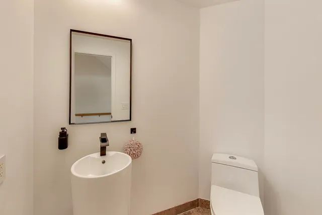 a bathroom with a toilet a sink and mirror