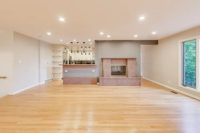 a view of large kitchen with granite countertop cabinets and refrigerator