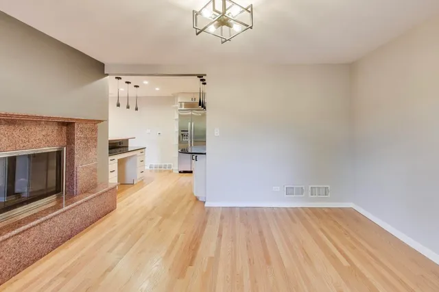 a view of empty room with wooden floor and fireplace