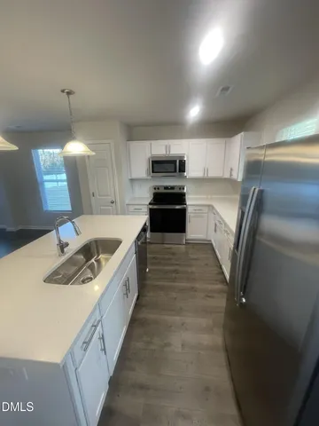 a kitchen with granite countertop a sink stove and refrigerator