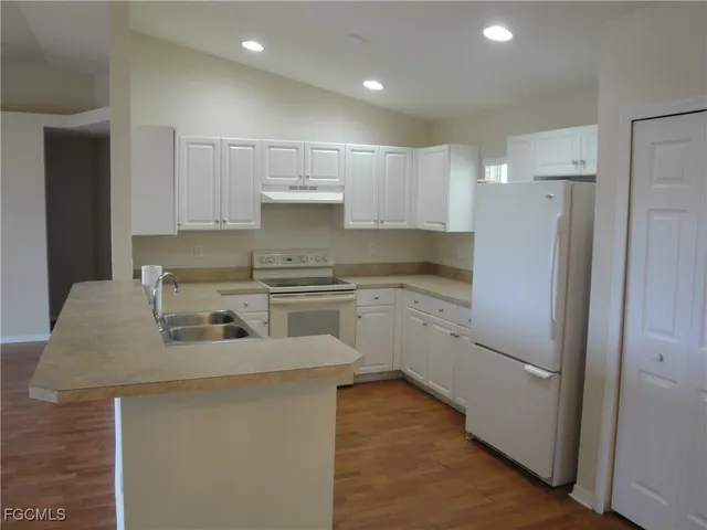 a kitchen with white cabinets and white appliances