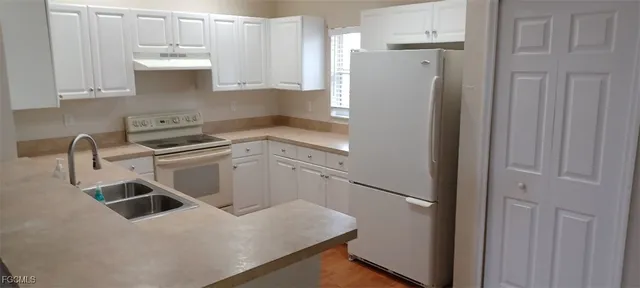 a kitchen with a refrigerator sink and cabinets
