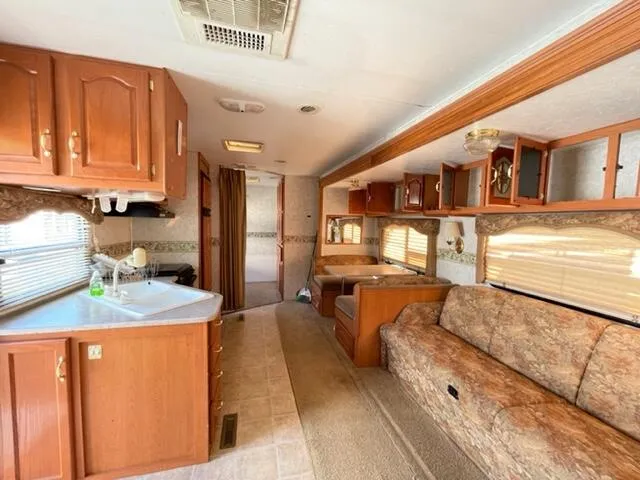 a living room with stainless steel appliances granite countertop furniture and a kitchen view