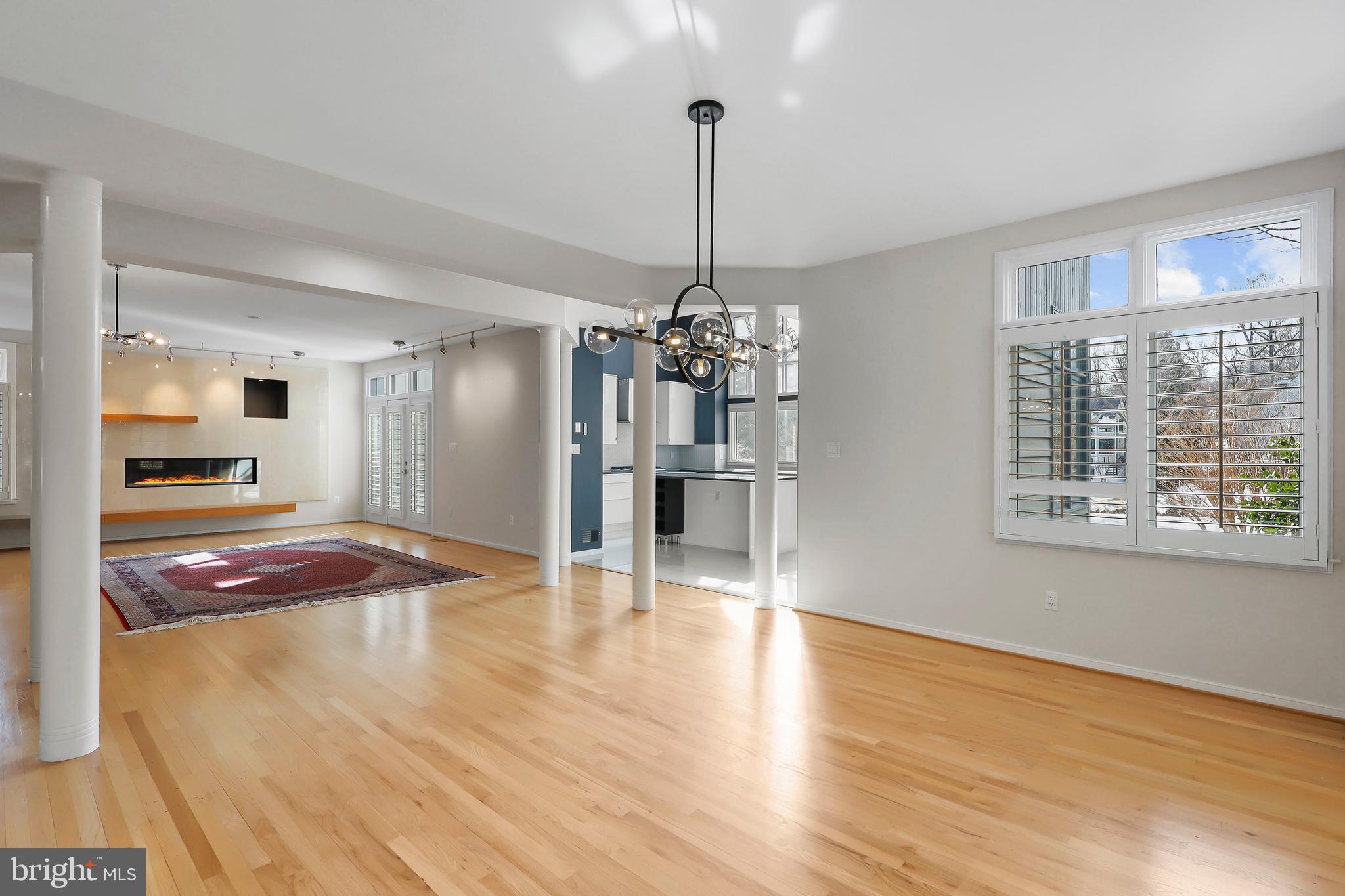 1460 Waterfront Road Reston, VA 20194 - Photo 11 of 63 a very nice looking room with wooden floor a kitchen view and a chandelier