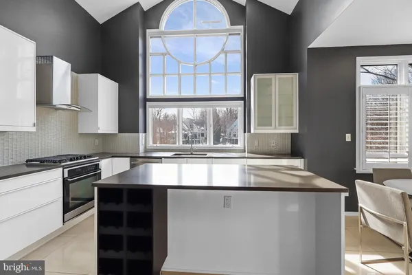 a kitchen with stainless steel appliances granite countertop a sink and a large window