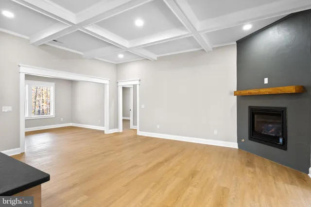 a view of an empty room with window and fire place
