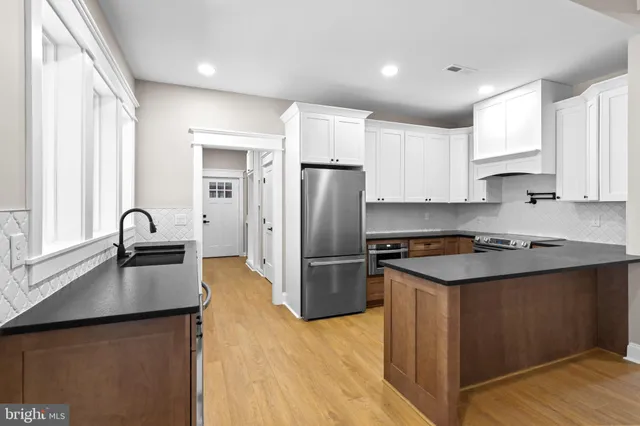 a kitchen with a refrigerator stove top oven and sink
