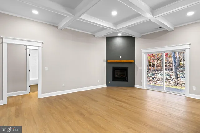 an empty room with wooden floor and a fireplace