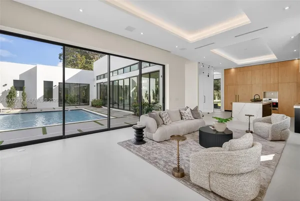 a living room with furniture large windows and a rug