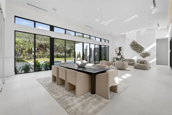a dining room with furniture and a floor to ceiling window