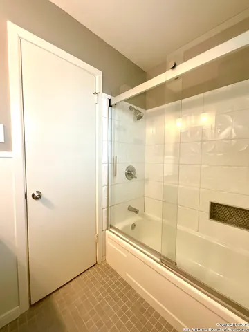 a bathroom with a glass shower door