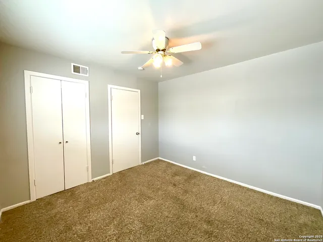 an empty room with closet and windows