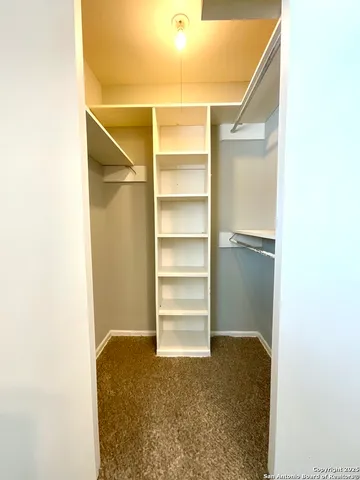 a view of walk in closet with empty racks