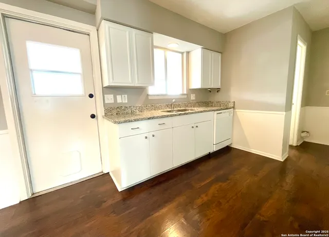 a bathroom with a granite countertop sink and a large mirror next to a window