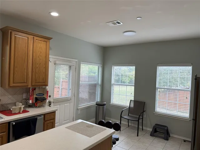 a kitchen that has a sink chairs and a refrigerator