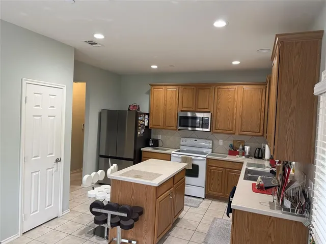 a kitchen that has a sink stainless steel appliances a counter space and a window