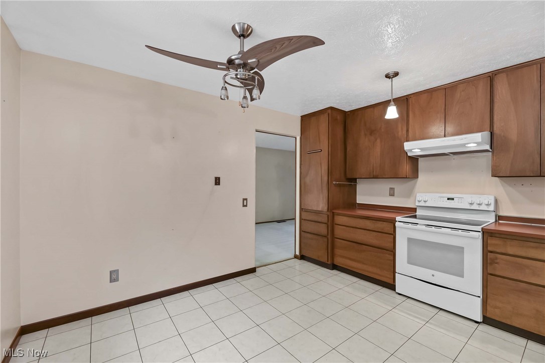 5076 North Barton Road North Ridgeville, OH 44039 - Photo 15 of 41 Kitchen featuring light tile patterned floors, white electric range, ceiling fan, pendant lighting, and a textured ceiling