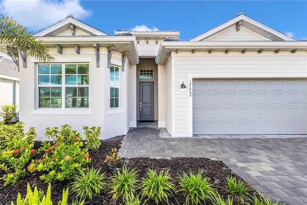 a large white kitchen with a white countertops a stove a couch and a dining table with wooden floor