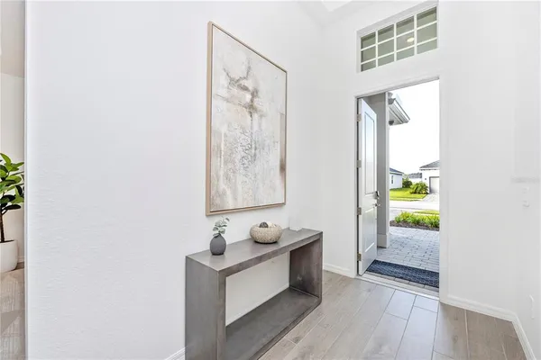 a view of a dining room with furniture a chandelier and wooden floor