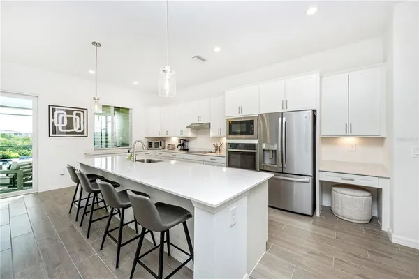 a dining room with furniture potted plants and wooden floor
