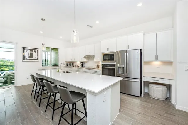 a dining room with furniture potted plants and wooden floor