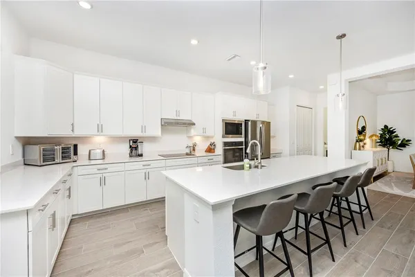 a view of a dining room and livingroom with furniture wooden floor a chandelier