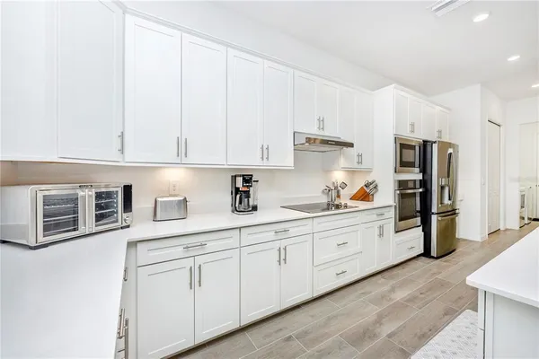 a living room with furniture white walls and kitchen view