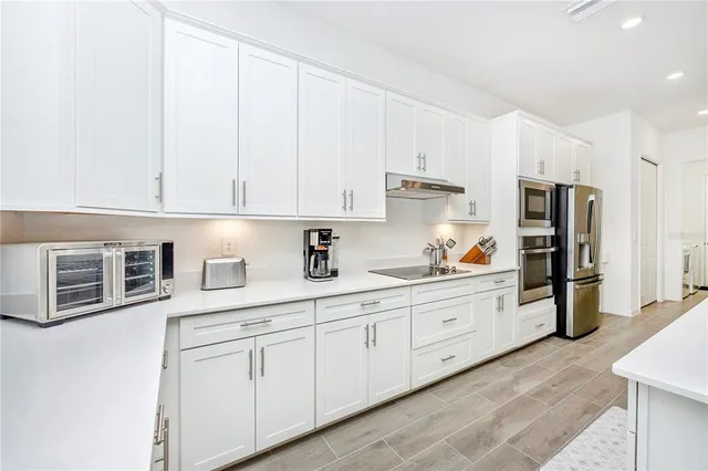 a living room with furniture white walls and kitchen view