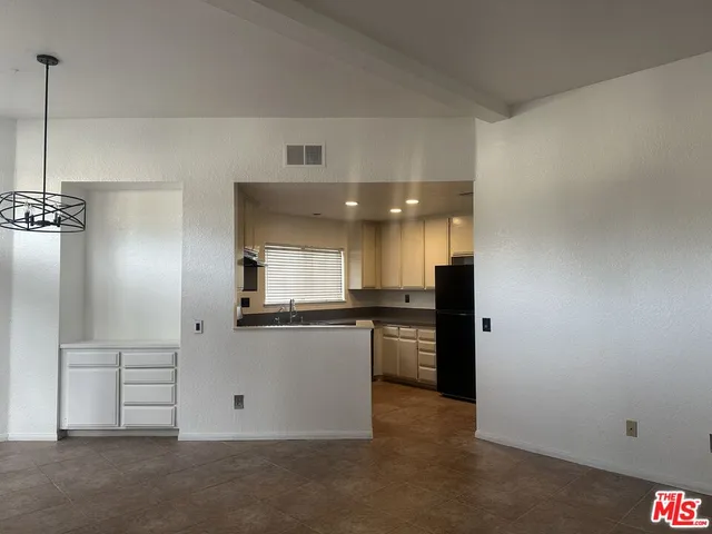 a kitchen with a sink a refrigerator and cabinets
