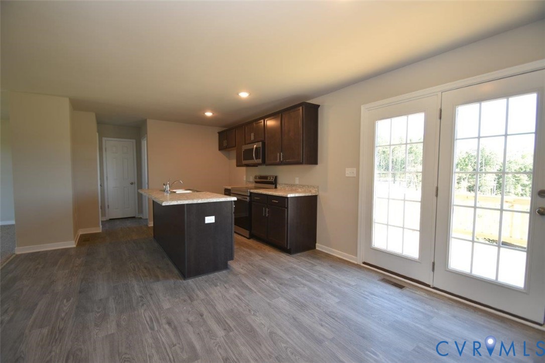 2570 Doctors Road Louisa, VA 23093 - Photo 8 of 17 a large kitchen with stainless steel appliances granite countertop a sink a stove a refrigerator counter space and wooden floor