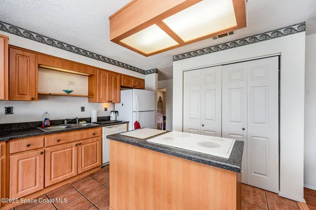 a kitchen with a table chairs refrigerator and window