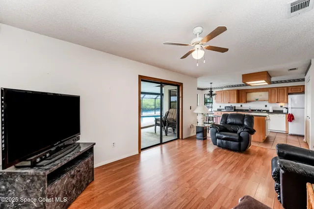 a dining room with furniture a chandelier and wooden floor